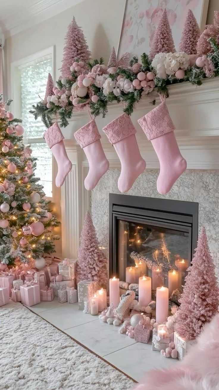 Pink Christmas aesthetic fireplace decorated with blush bottle-brush trees, pink stockings, pastel ornaments, and soft glowing candles beside a snowy pink Christmas tree.