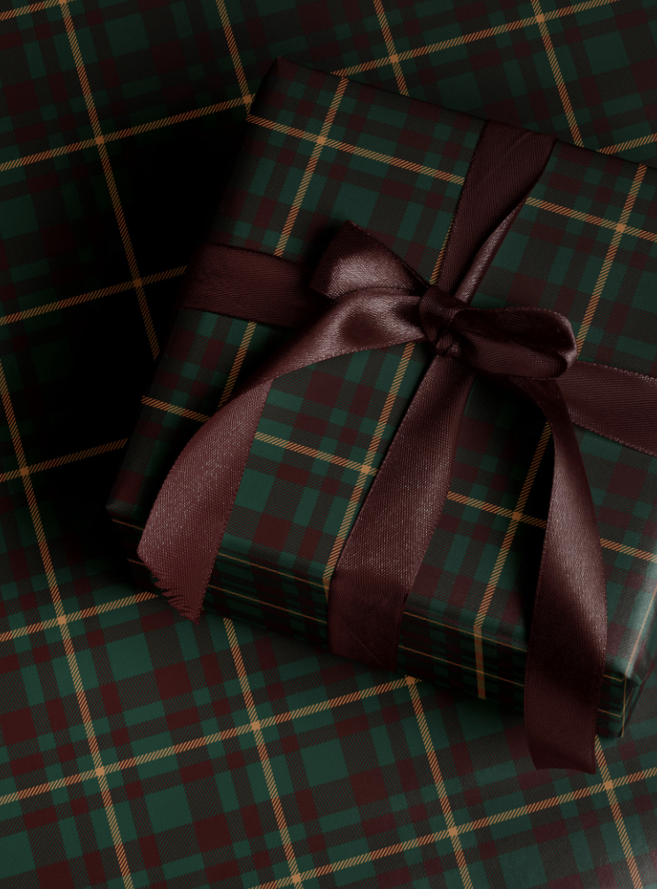 Beautiful Ralph Lauren-inspired Christmas gift wrapped in green and burgundy tartan plaid paper with a deep burgundy satin ribbon bow, capturing the timeless elegance of classic holiday style.