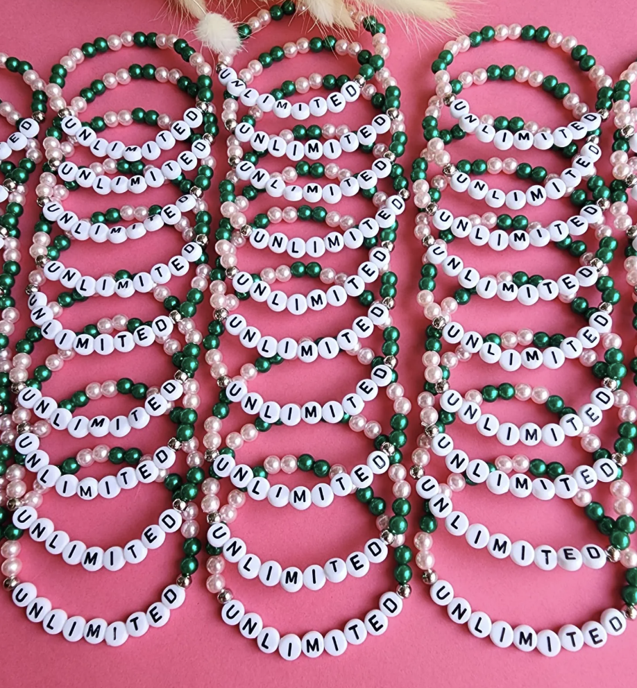 Wicked-themed DIY bracelets made with green, white, and pink beads spelling out the word 