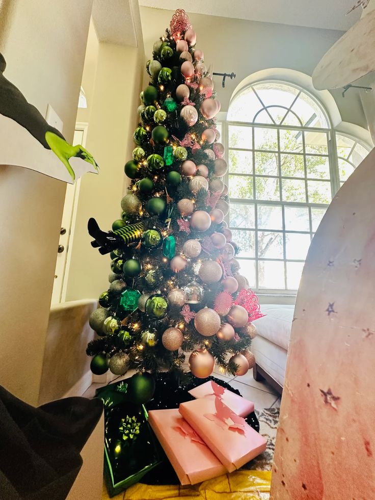 Wicked Christmas tree decorated with pink and green ornaments, sparkling lights, and playful Grinch-themed details for a fun holiday display.