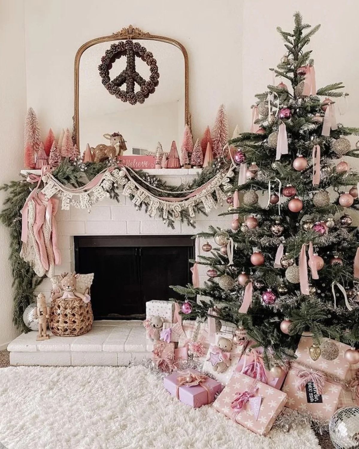 Cozy living room with a pink Christmas tree, blush bottle-brush trees on the mantel, pink stockings, and pastel-wrapped gifts for a soft holiday aesthetic.