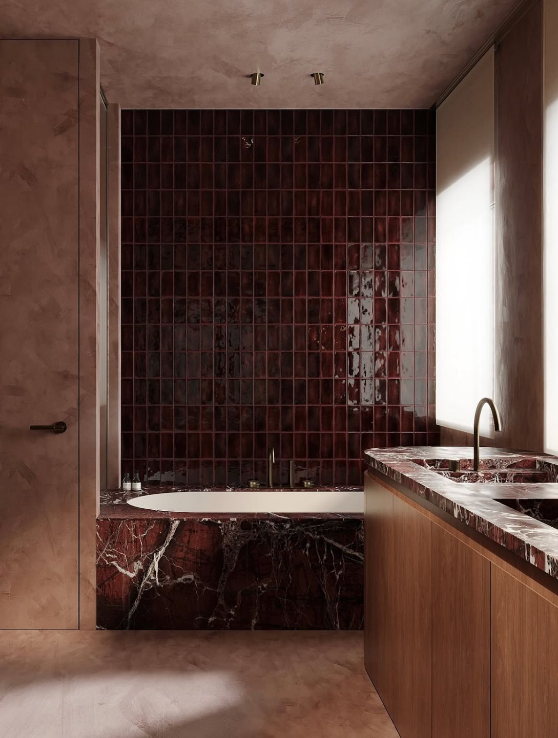 A luxurious bathroom featuring a deep red marble tub surround, glossy red square wall tiles, a double marble vanity with wood cabinetry, and warm neutral plaster walls.