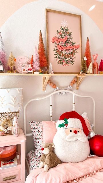 Cozy kids' bedroom decorated with pink Christmas bedding, bottle-brush trees, a Merry Christmas art print, and festive holiday accents.