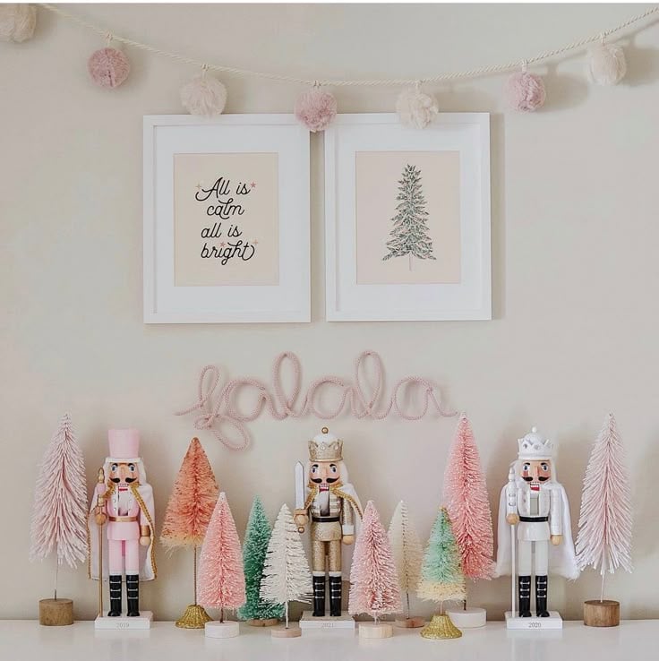 Pink and white nutcracker display with pastel bottle-brush trees, pom-pom garland, and framed Christmas art for a soft pink holiday aesthetic.
