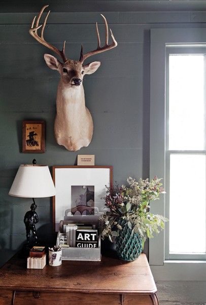 Cozy deer aesthetic console table featuring a mounted deer accent, layered artwork, and warm neutral decor