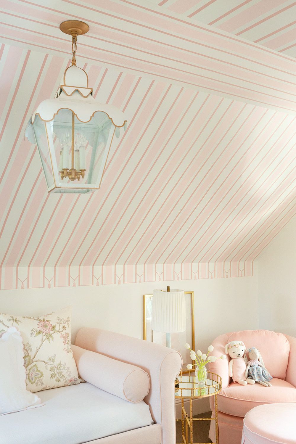 Kids striped ceiling bedroom featuring soft pink and white stripes on a sloped ceiling with cozy seating and playful decor.