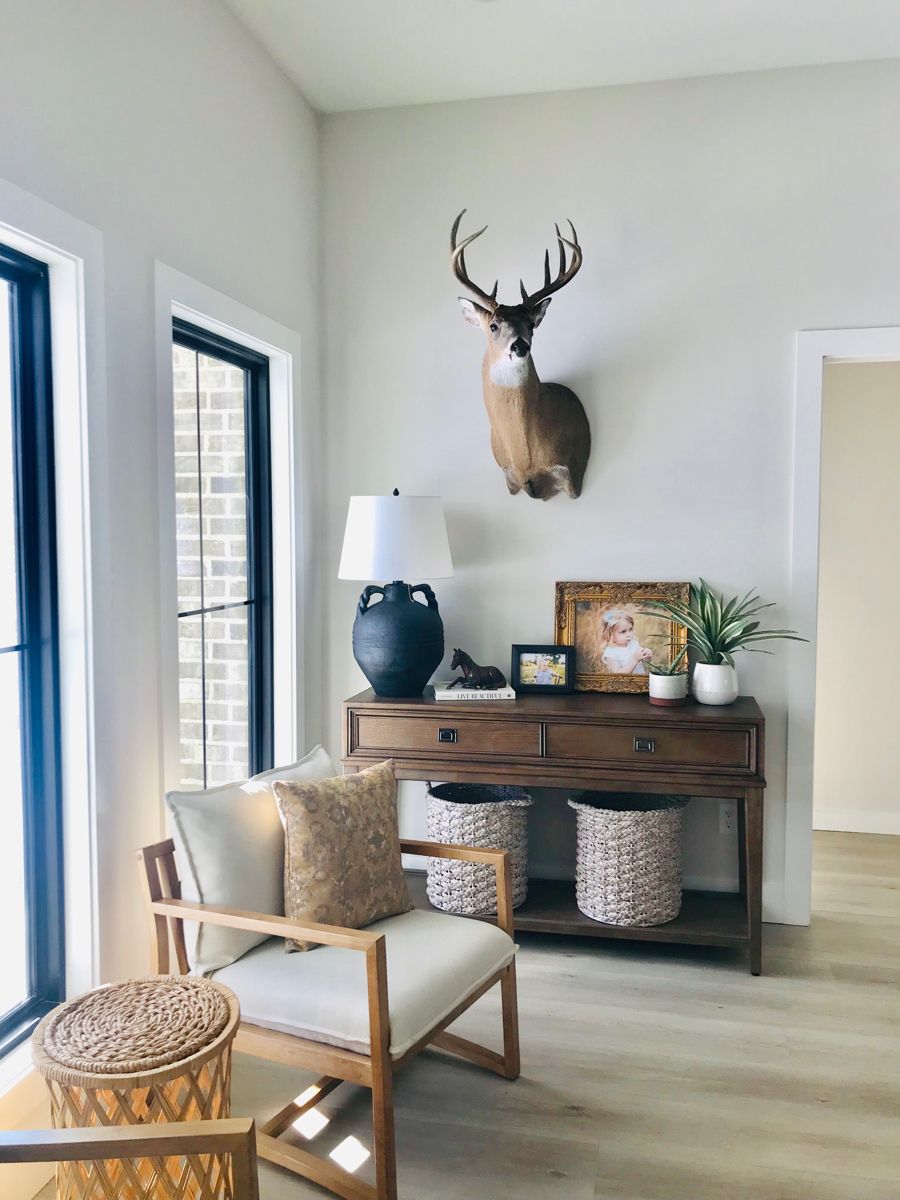 Minimal deer aesthetic entryway featuring a mounted deer accent, neutral furniture, and soft natural textures