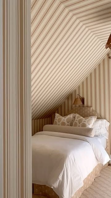 Neutral striped ceiling bedroom with beige and cream stripes on a sloped ceiling, creating a warm and cozy sleeping space.
