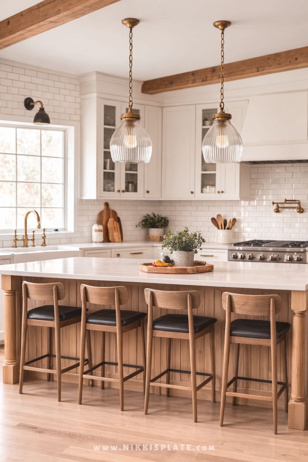 Ribbed glass pendant lights with brass hardware hanging above a light wood kitchen island in a bright farmhouse kitchen.