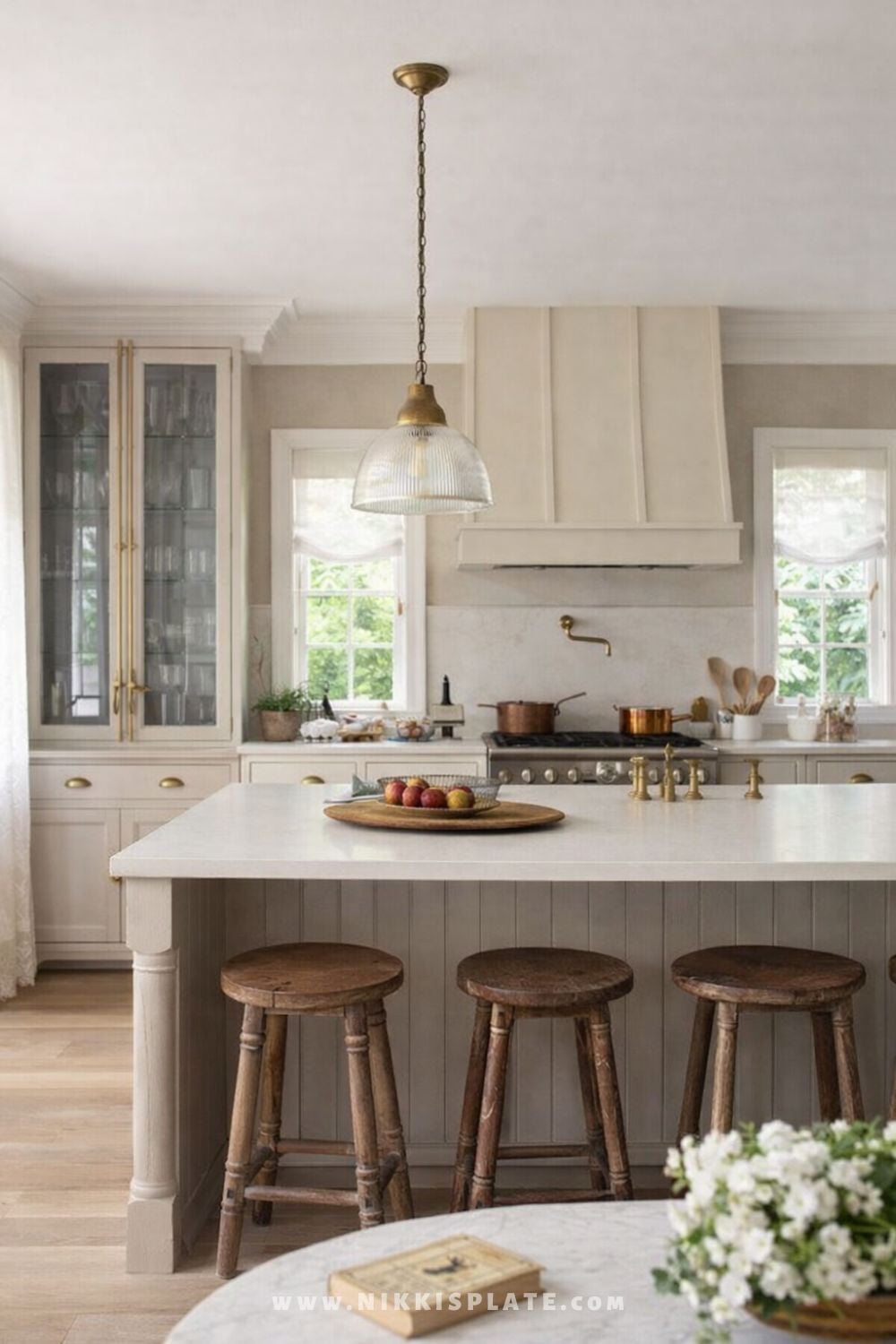 Vintage ribbed glass pendant light with brass hardware hanging above a farmhouse kitchen island with wooden stools.