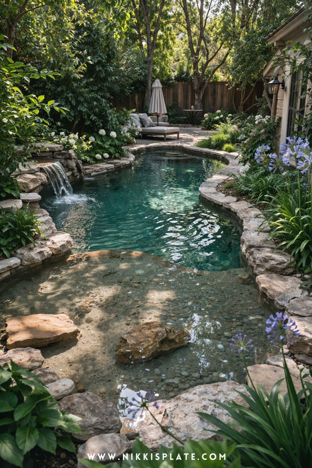 Small backyard natural swimming pool with stone edging, pebble bottom, and cozy seating area surrounded by greenery