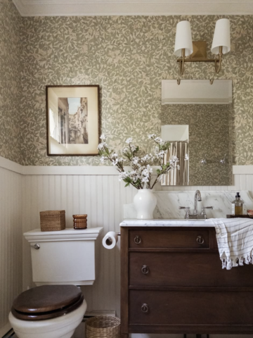 upgrade your home on a budget with a charming bathroom refresh featuring floral wallpaper, a wood vanity, and classic cozy details