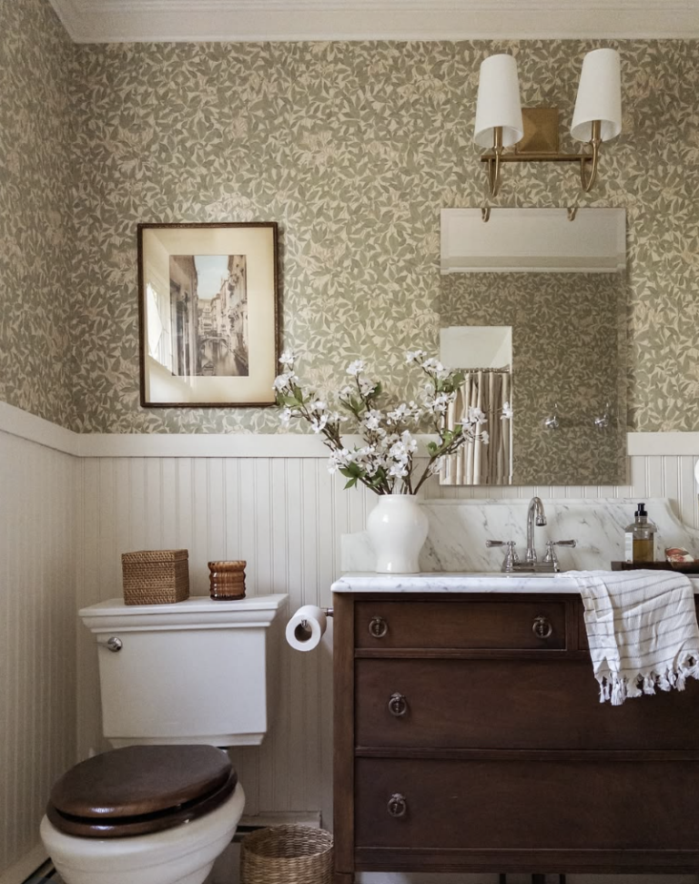 upgrade your home on a budget with a charming bathroom refresh featuring floral wallpaper, a wood vanity, and classic cozy details