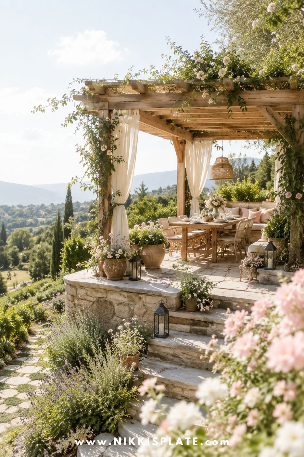 Sloped backyard landscaping with a pergola on a terrace, stone patio steps, climbing flowers, outdoor dining space, and soft farmhouse garden views.