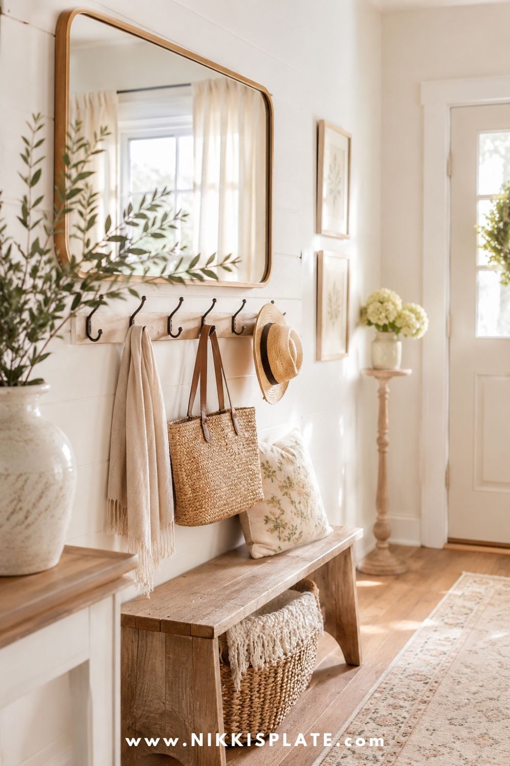 Bright farmhouse entryway with a large mirror above wall hooks for bags, hats, and everyday storage.