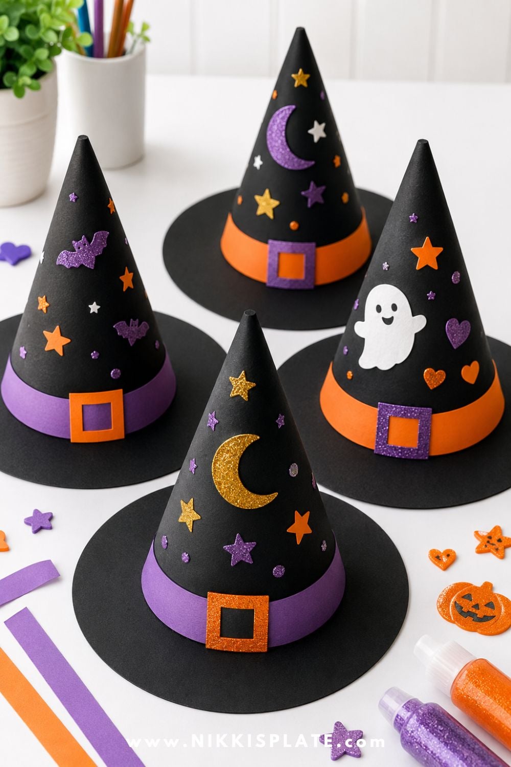 Black paper witch hats decorated with stars, moons, stickers, and colorful accents for an easy Halloween classroom craft for kids.