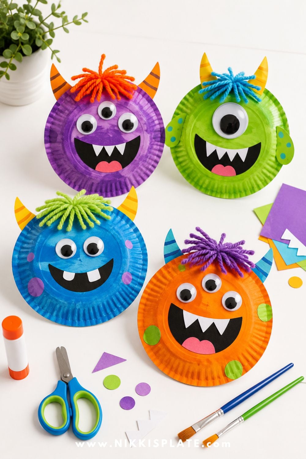Colorful friendly monster paper plate crafts with googly eyes, paper teeth, horns, and yarn hair for a silly Halloween craft for kids.