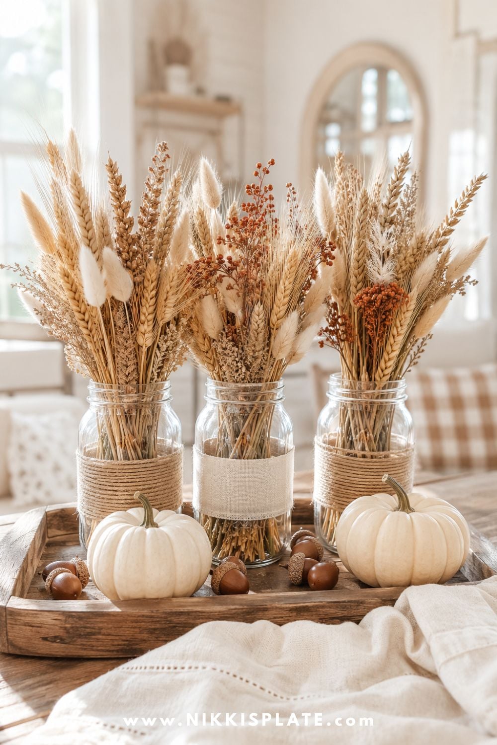Mason jars wrapped with linen and twine and filled with dried wheat, bunny tails and soft autumn grasses.