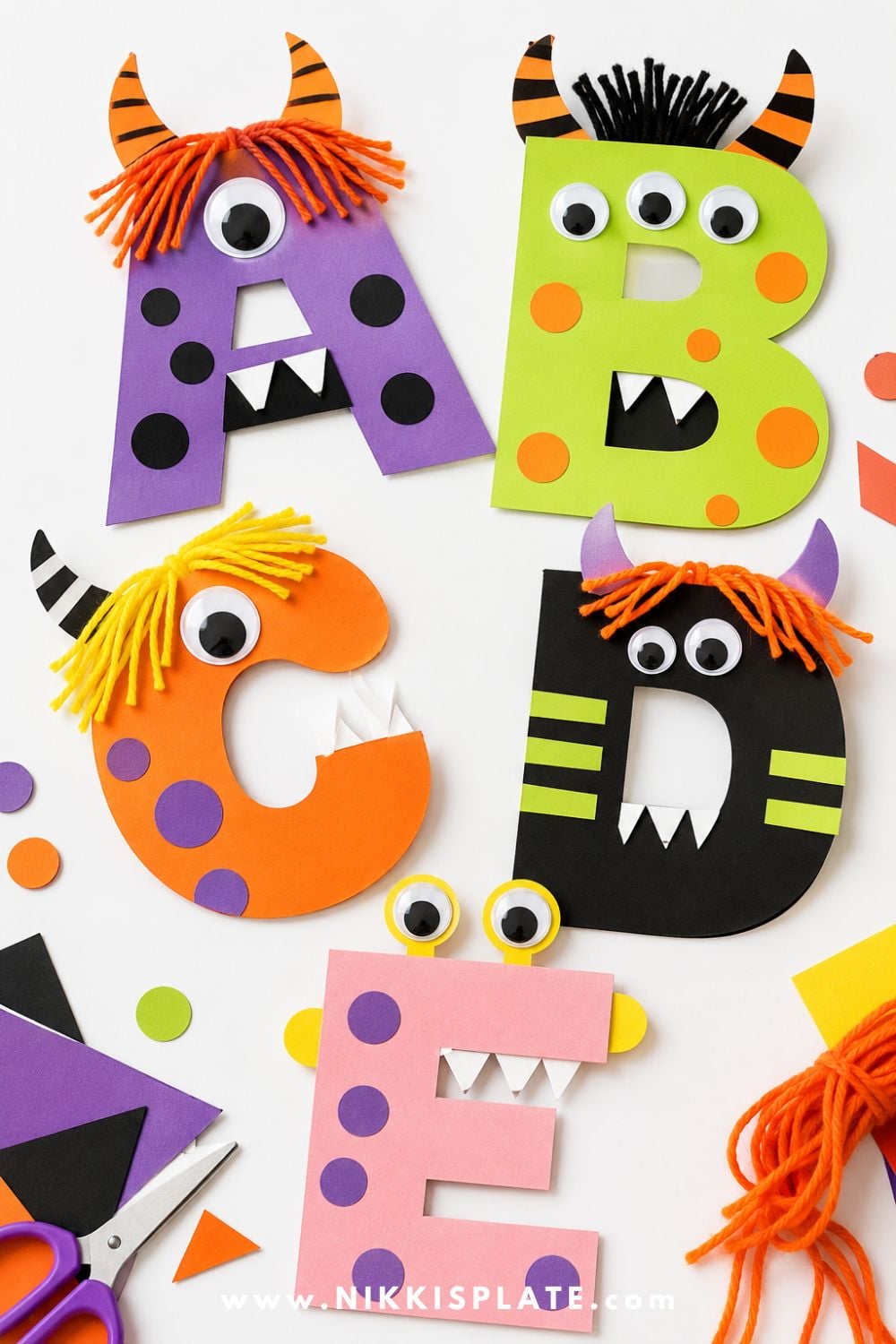 Colorful paper letters decorated as silly monsters with googly eyes, yarn hair, horns, and teeth for a fun Halloween classroom craft for kids.