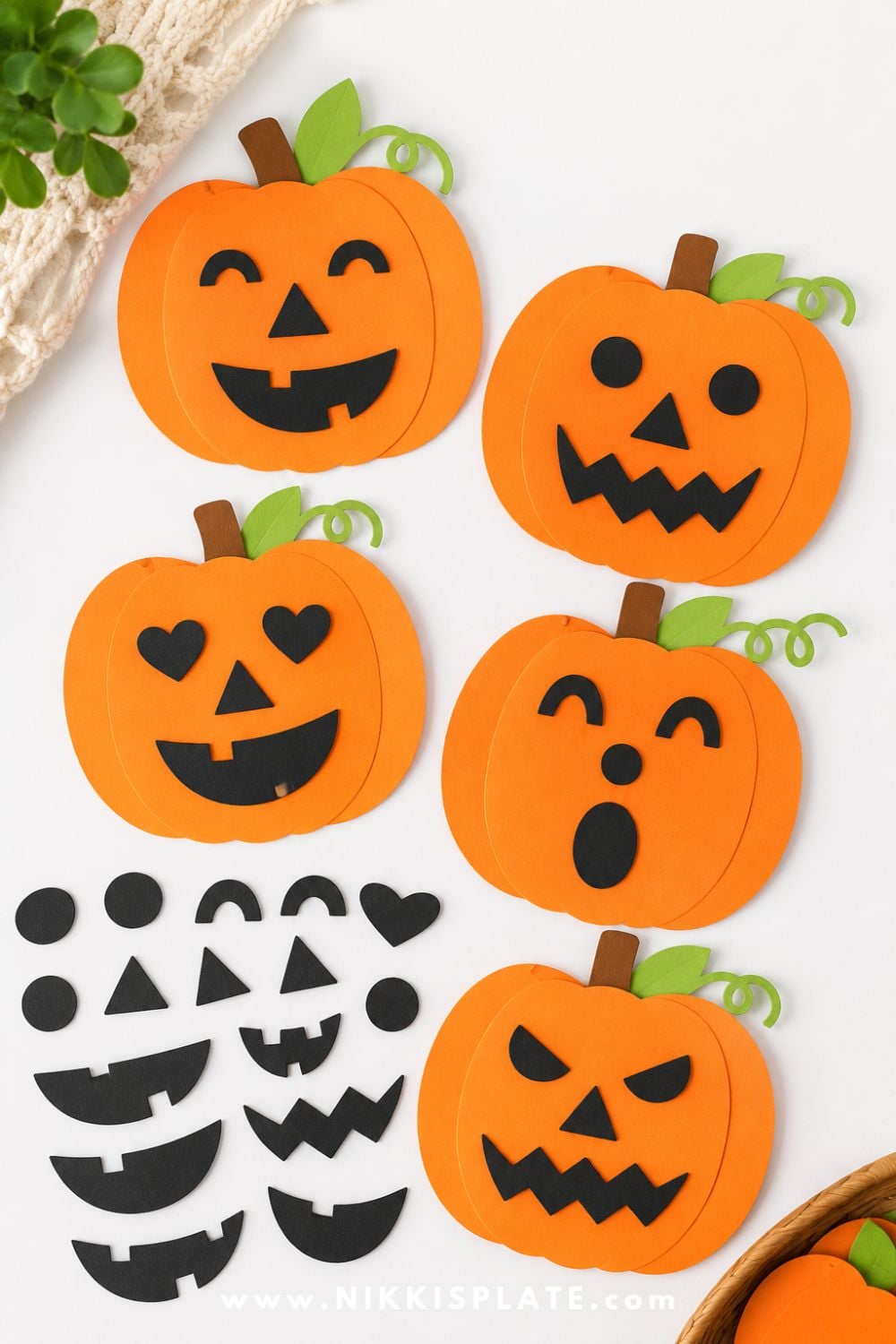 Orange paper pumpkins with mix-and-match black paper eyes, noses, and mouths for a fun Halloween craft and shape activity for kids.