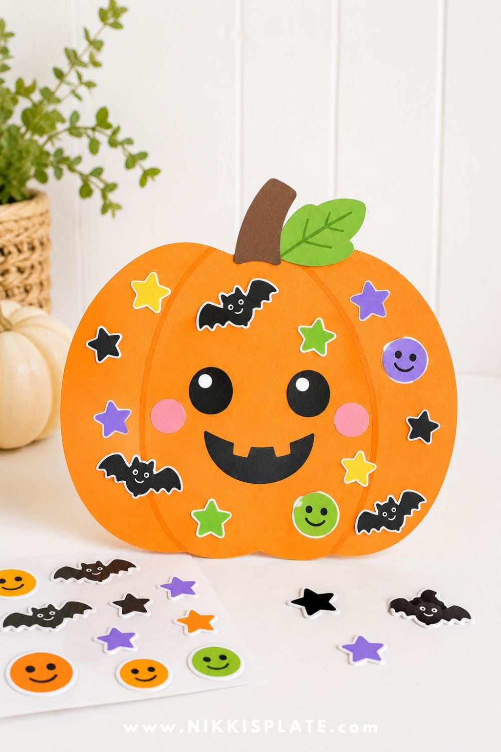 Large orange paper pumpkin decorated with Halloween stickers for a simple low-mess toddler Halloween craft and easy kids activity.