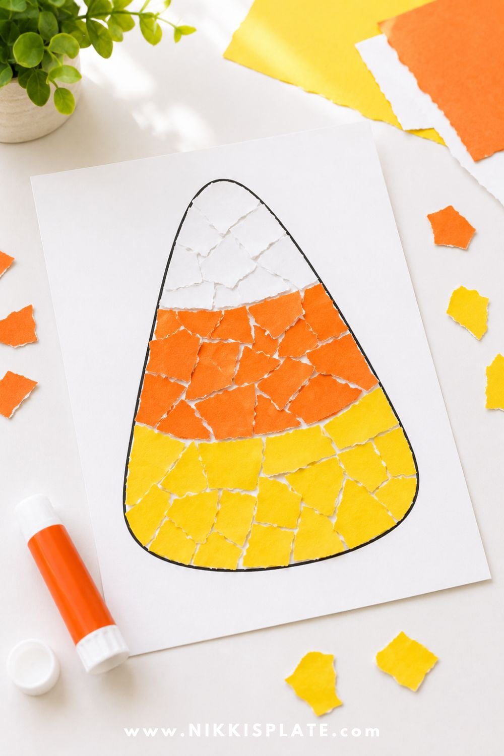 Torn paper candy corn craft filled with yellow, orange, and white paper pieces for a simple Halloween craft and fine motor activity for kids.