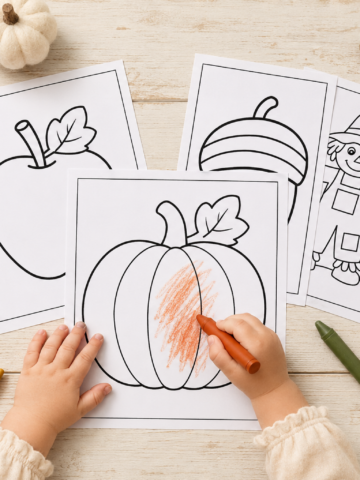 Toddler coloring a pumpkin surrounded by free fall coloring pages featuring a leaf, apple, acorn, scarecrow and autumn tree.