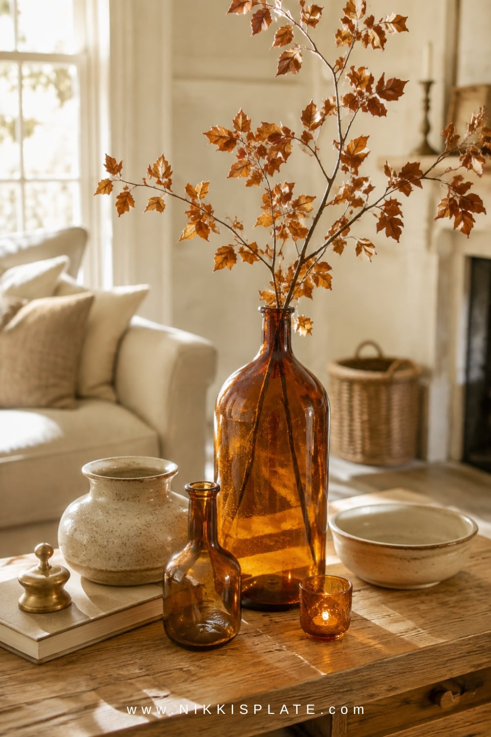 Amber glass vase and votives adding a warm honey glow to a bright neutral fall living room.