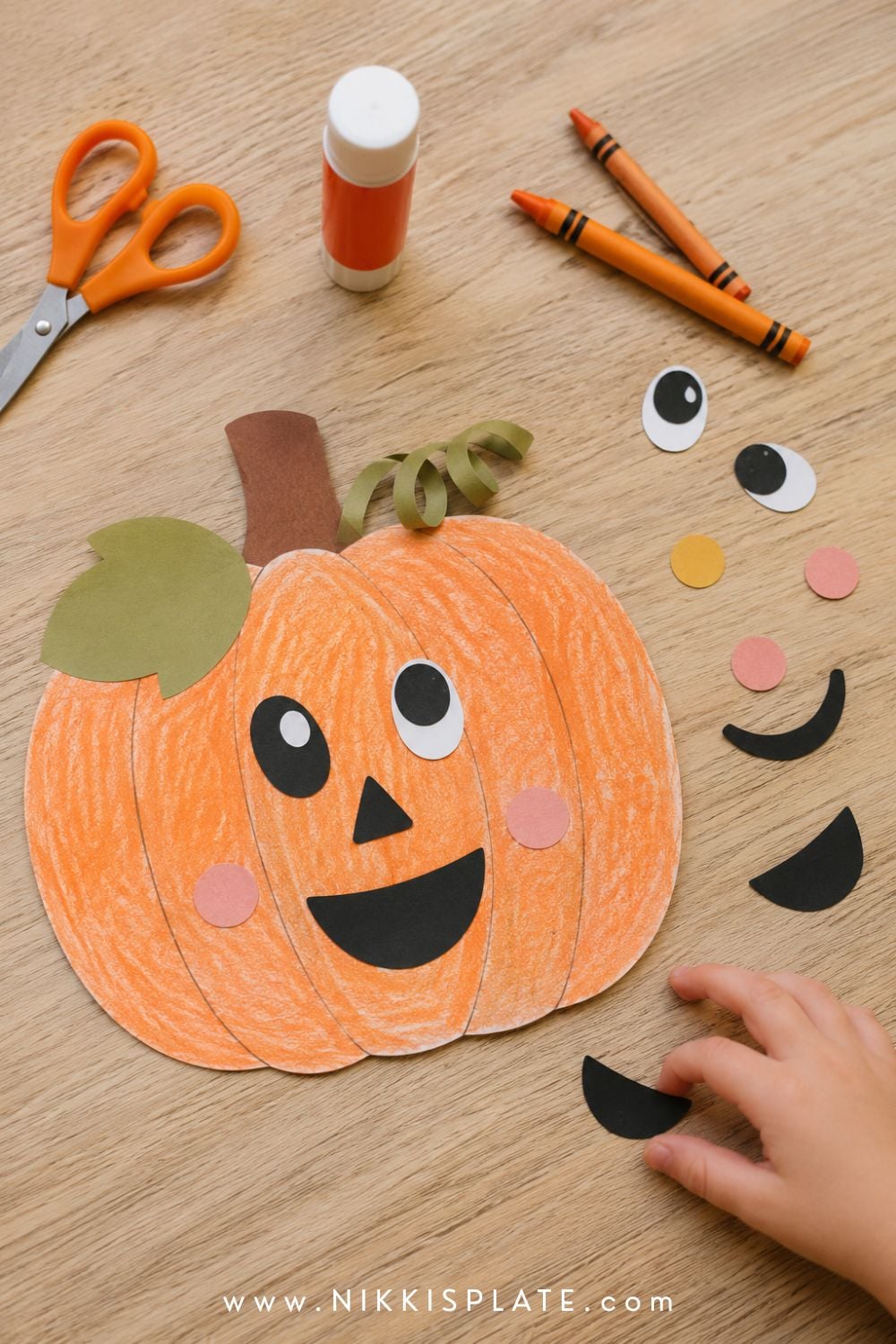Printable build-a-pumpkin craft with a friendly mismatched face, paper leaf, curled vine and extra decorating pieces.