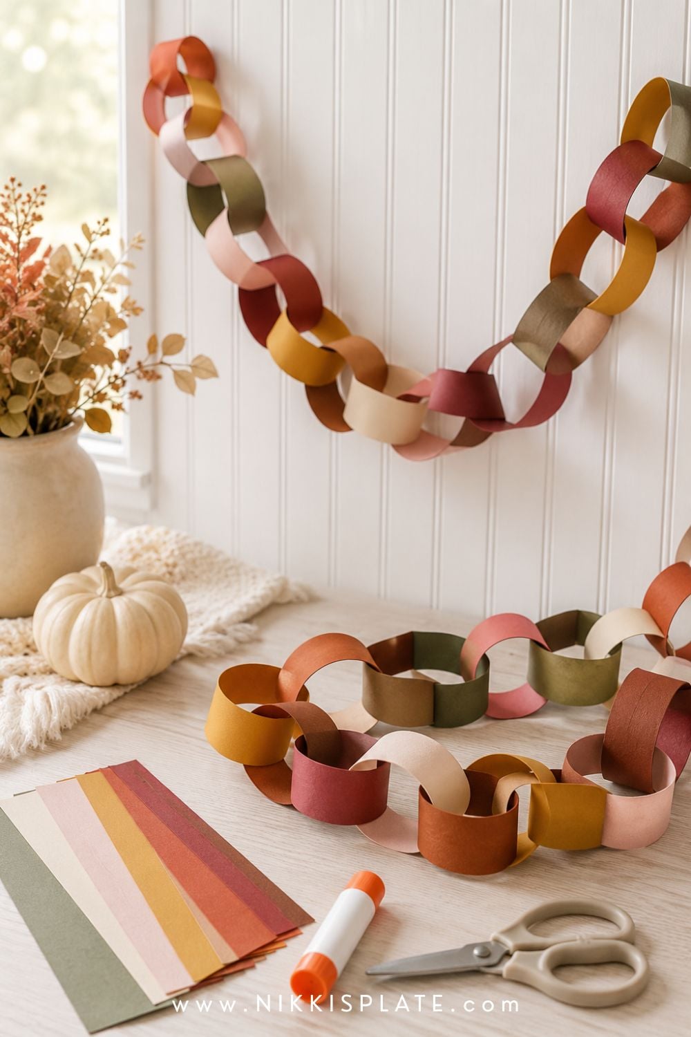 Fall color paper chain craft for kids made with rust, mustard, cranberry, cream and olive paper loops.