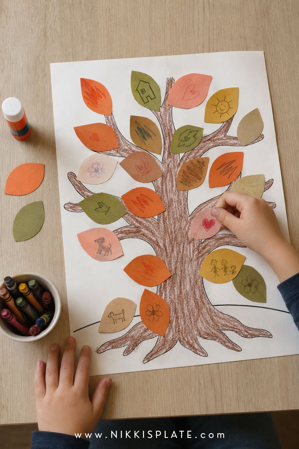Printable fall gratitude tree covered with colourful paper leaves featuring simple child-drawn hearts, pets and family pictures.