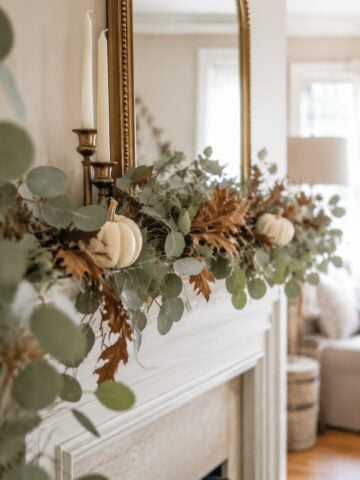 Style a warm and welcoming fireplace with these fall mantel decor ideas, from neutral pumpkins and leafy garlands to candlelight, vintage artwork, mirrors, and beautiful autumn stems.