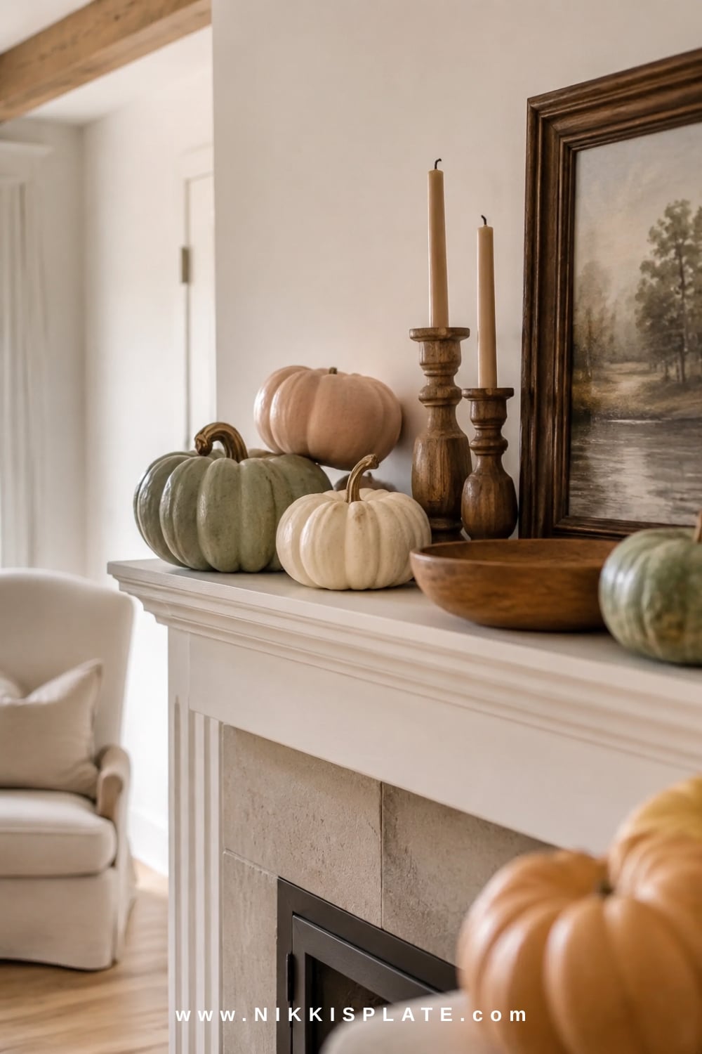 Heirloom pumpkins in cream and muted green paired with warm wood accents on an airy farmhouse fireplace mantel.