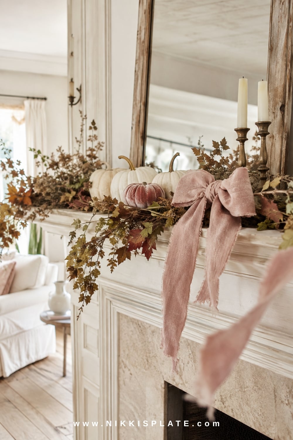 Raw-edge oatmeal linen ribbon woven through a soft fall garland above a white mantel with brass candlesticks and cream pumpkins.
