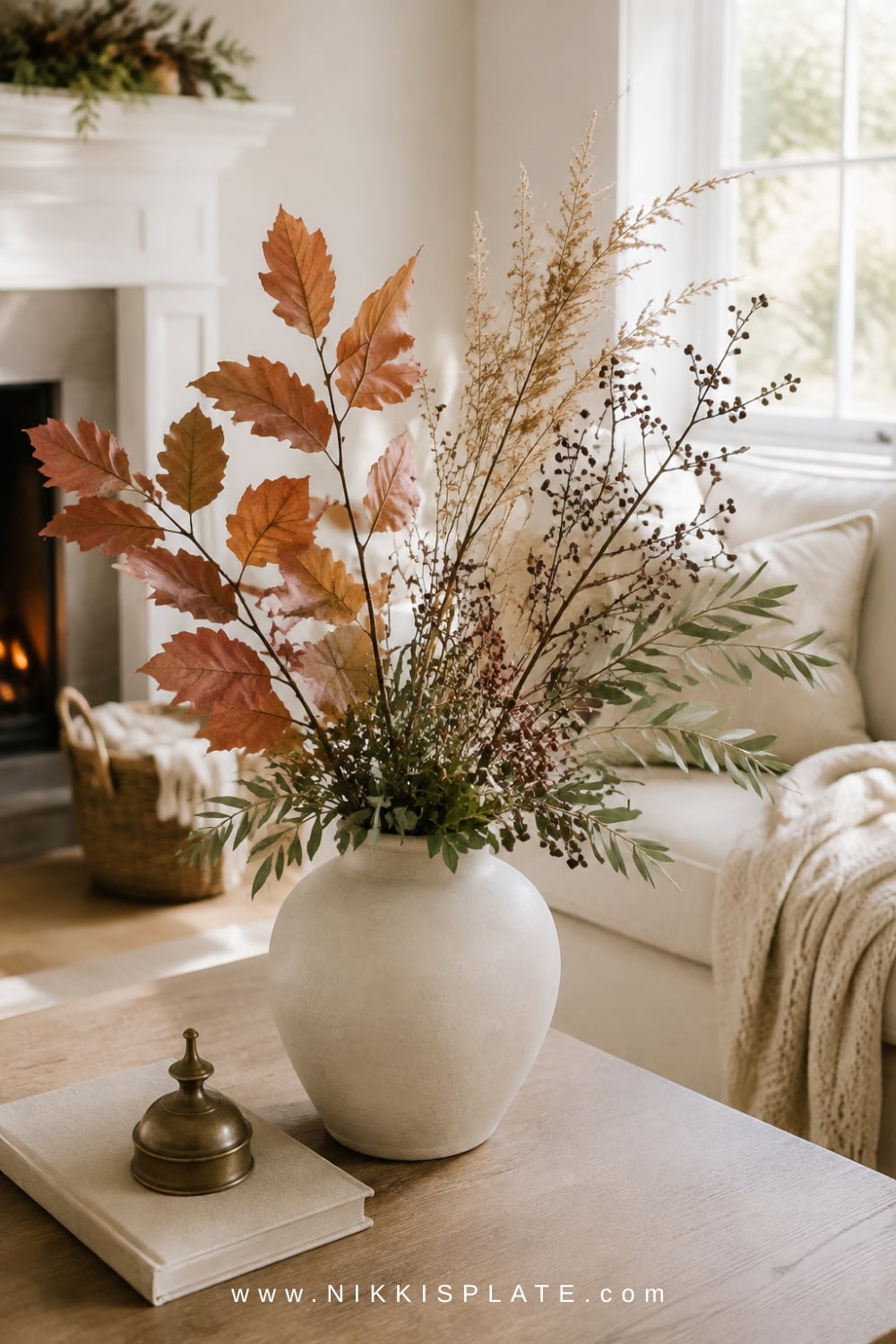 Cream vase combining realistic faux foliage, dried grasses, berry stems and fresh olive-green clippings.