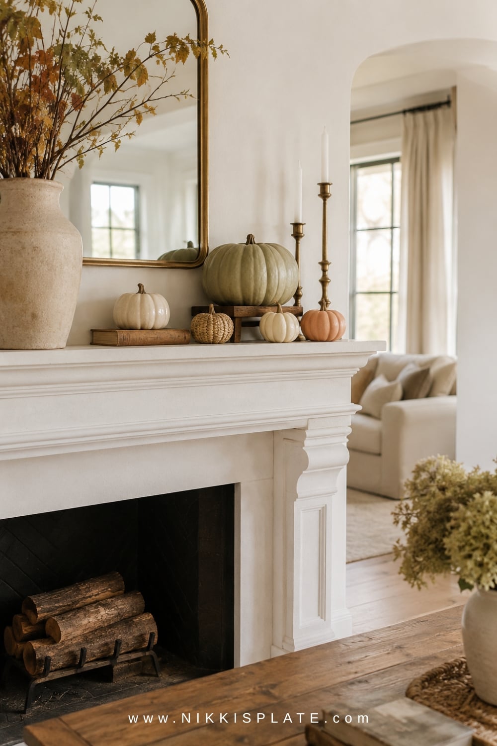 Five cream, sage and woven pumpkins grouped at varied heights on one side of a fall fireplace mantel.