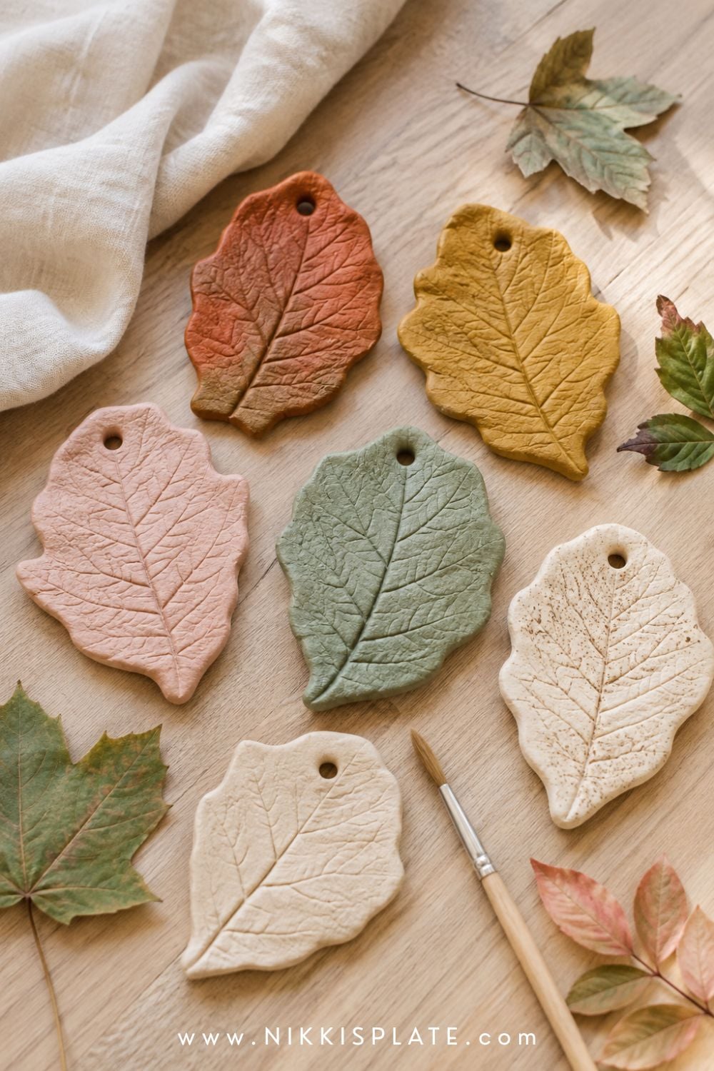 Salt dough leaf impressions painted rust, mustard, cream and green with detailed natural leaf veins.