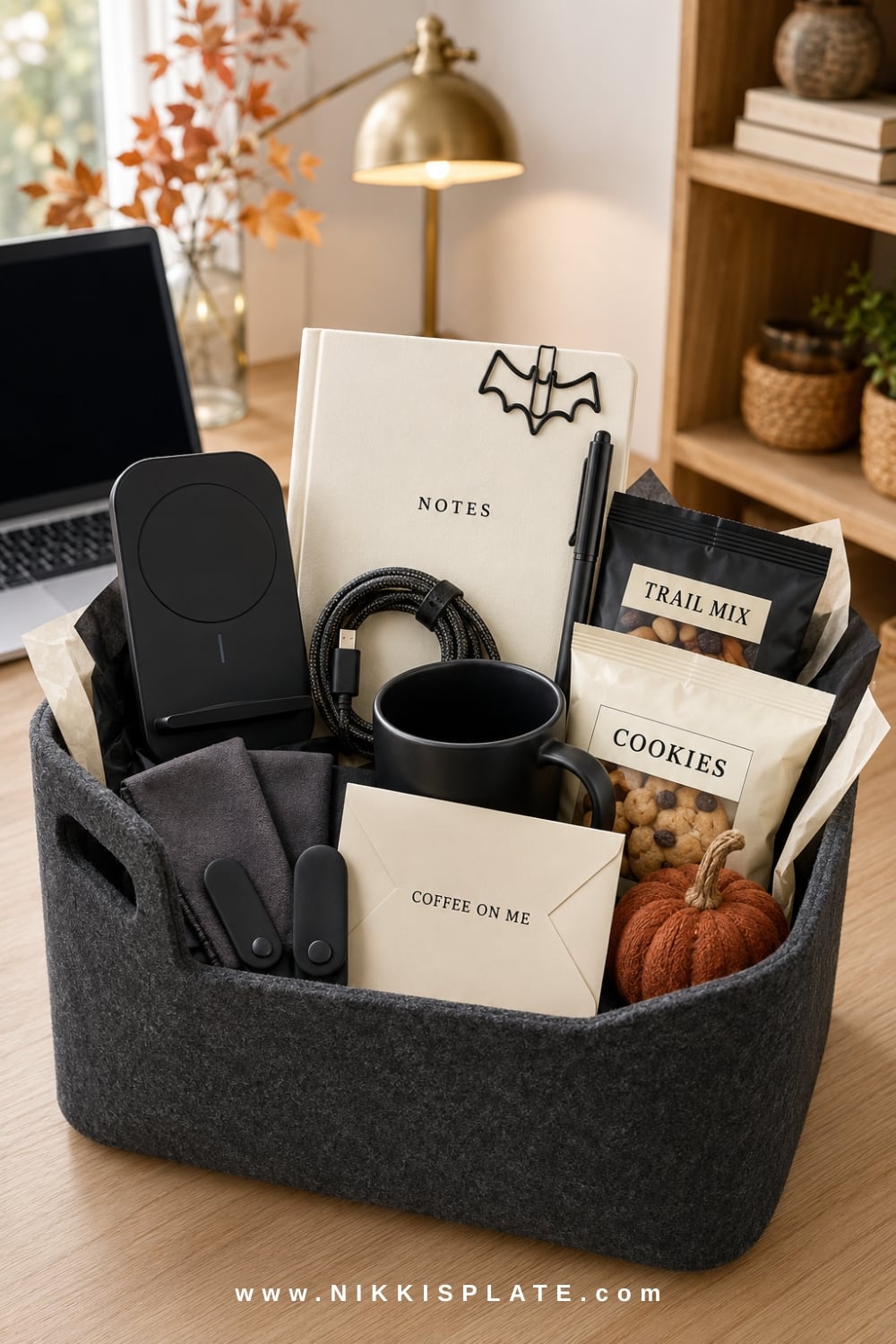 Work-from-home tech boo basket for men with charging accessories, a notebook, mug, snacks and desk essentials.